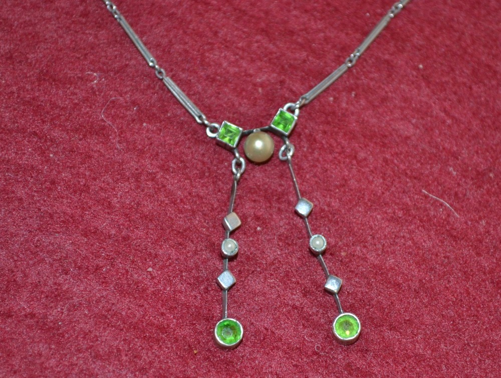 A white metal peridot and seed pearl pendant necklace