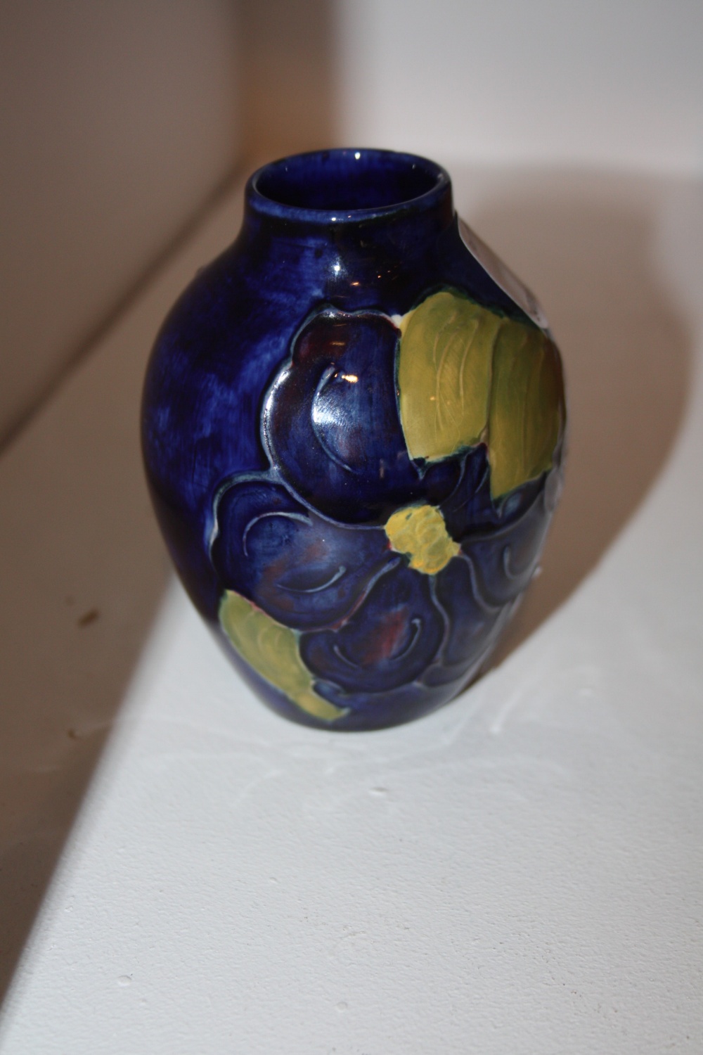 A Moorcroft vase painted in tones of blue and green