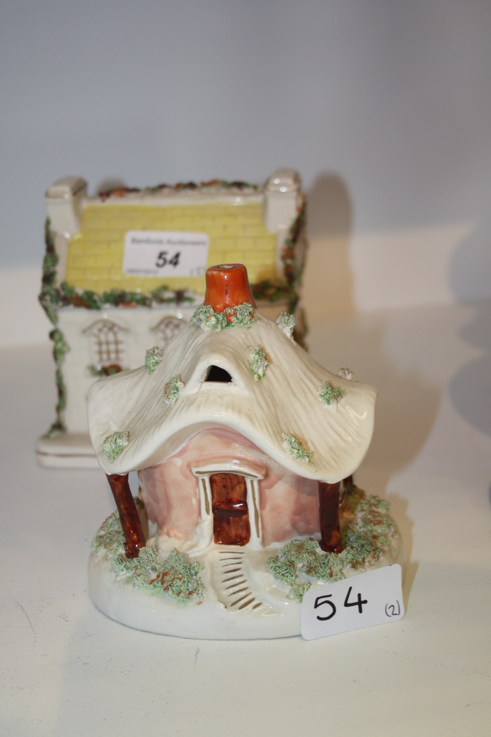 A Staffordshire cottage pastille burner, a Staffordshire ceramic money box (2)