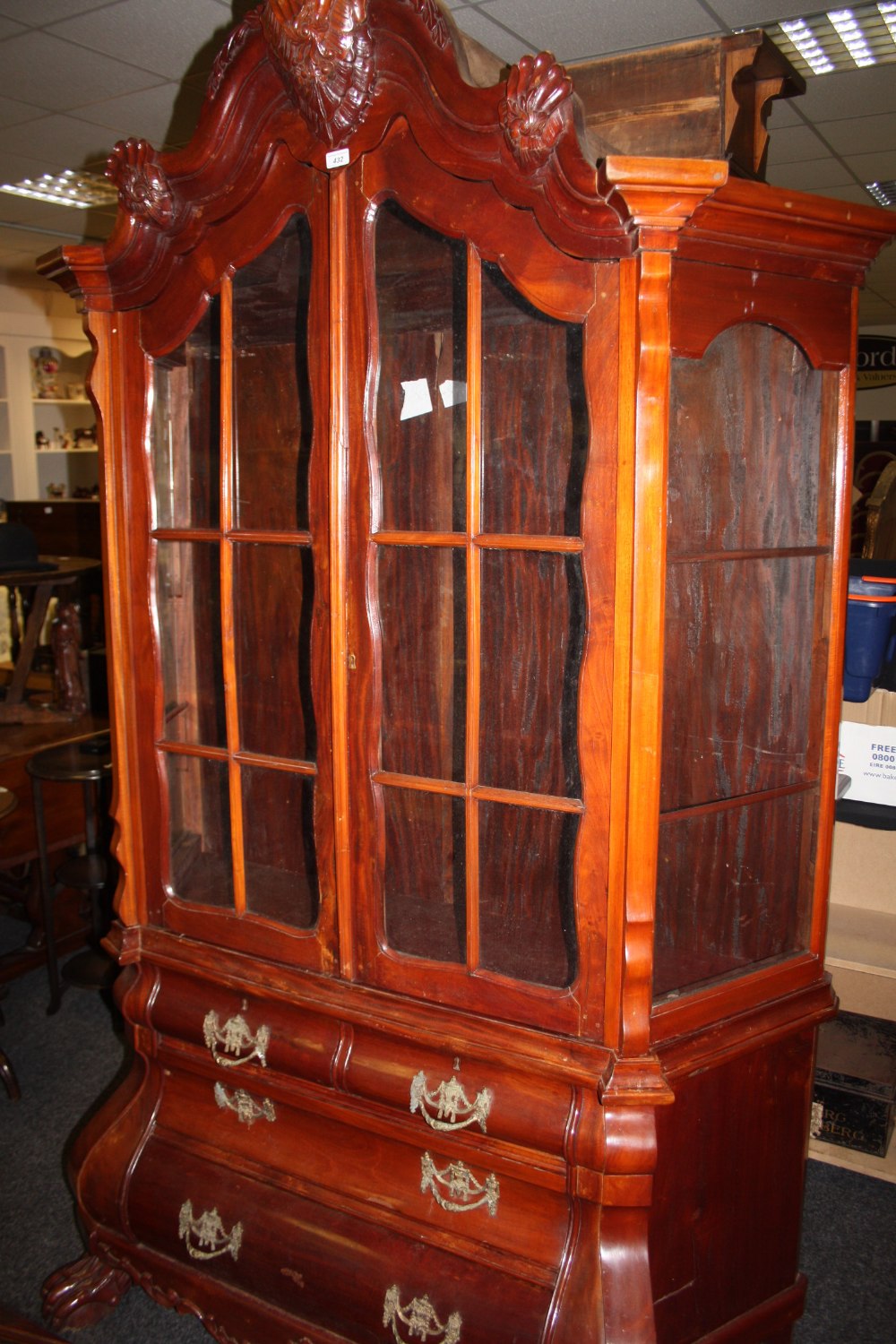 A 20th century Dutch mahogany display cabinet/ chest of drawers, with lion pad feet