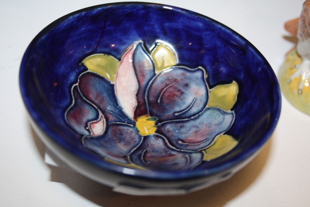 A Moorcroft pin dish, tube lined and painted in tones of blue and green