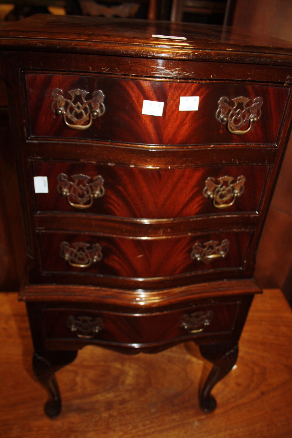 A mahogany serpentine chest on stand, fitted with four drawers, 20th century