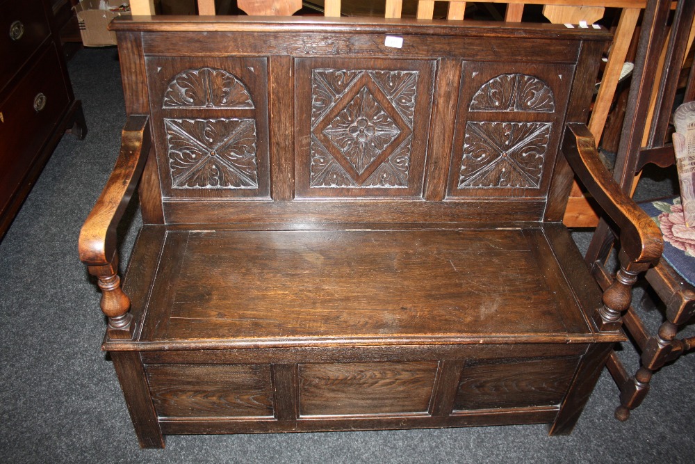 A 19th/20th century oak monk`s bench, three panel carved back.