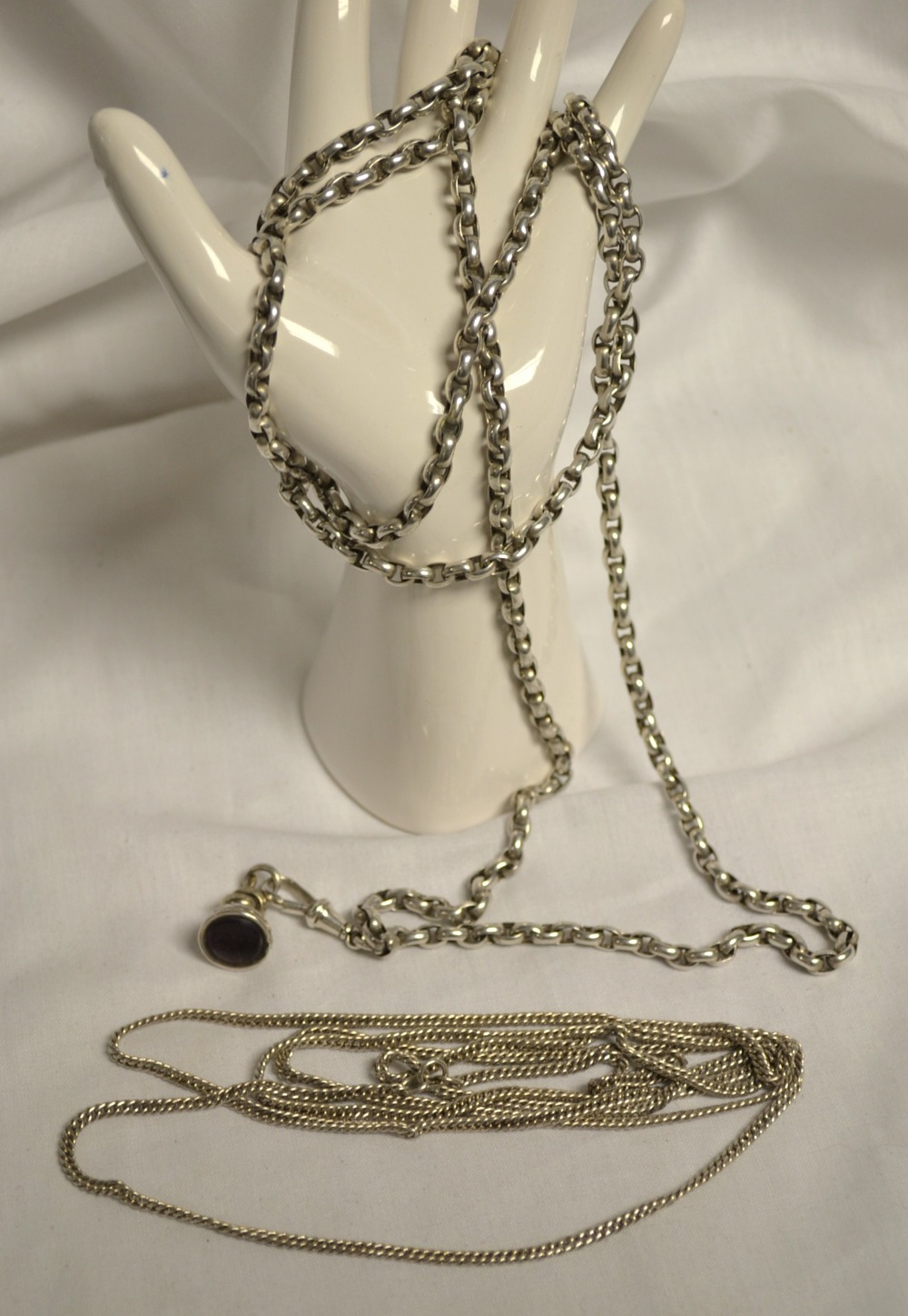 A silver coloured metal guard chain with fob; another guard chain (2)