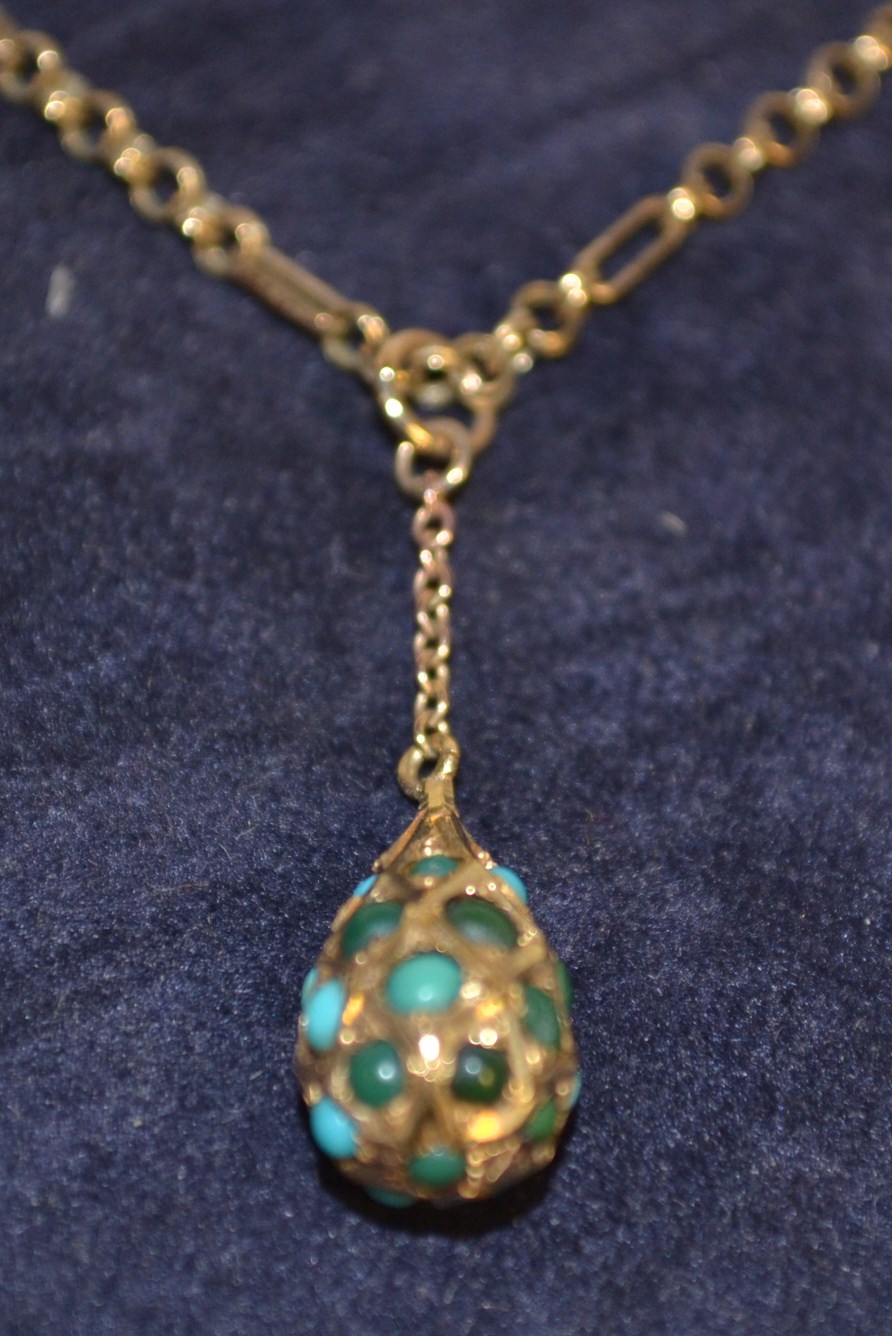 A 9ct gold fancy link necklace, the suspended pear shaped pendant set with turquoise stone,