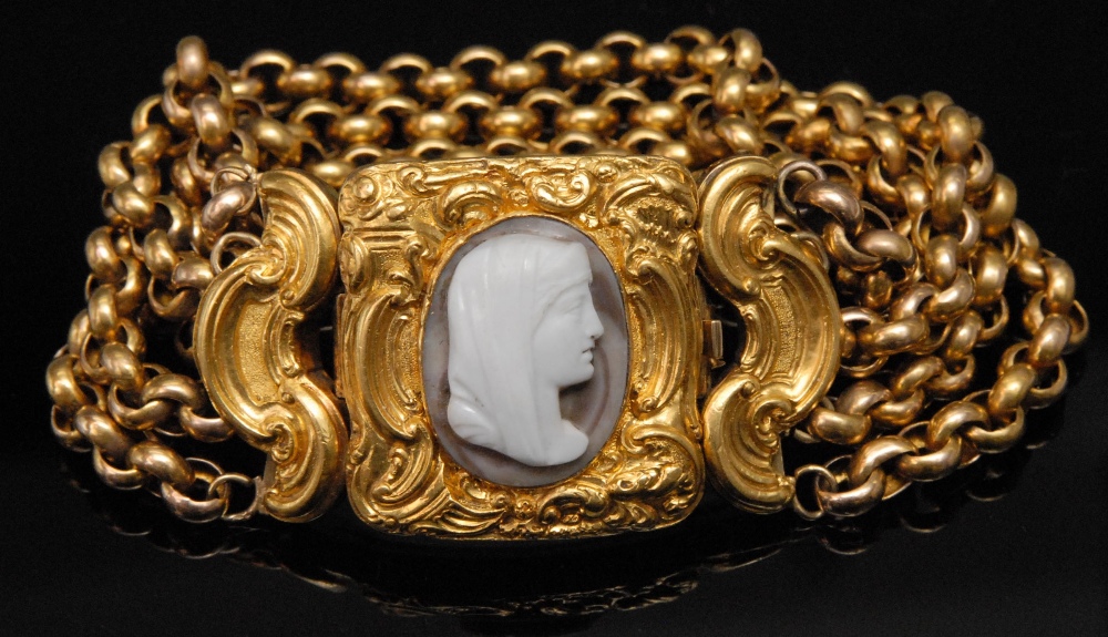 A mid 19th century 15ct gold chain bracelet, the chased scroll work clasp set with a hardstone