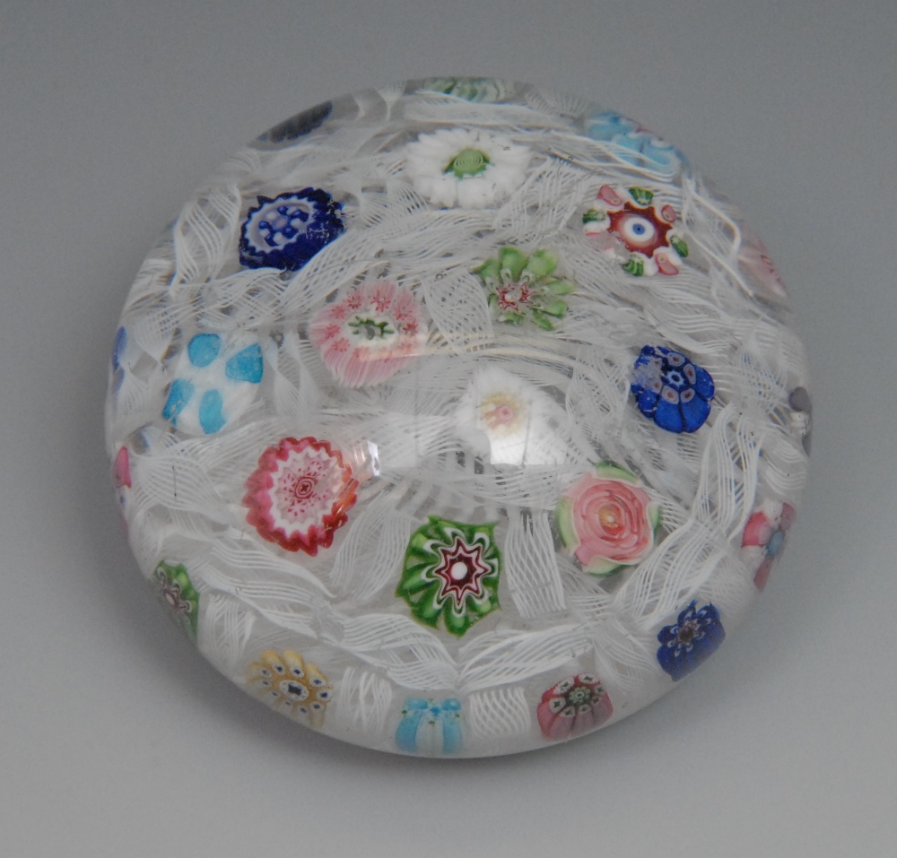 A 19th century Baccarat millefiori domed paperweight, inset coloured canes against an upset muslin