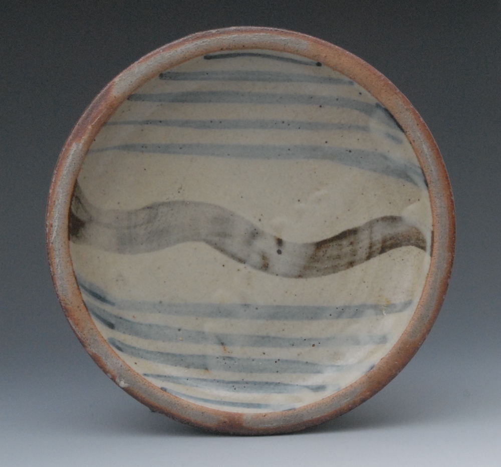 A Leach St Ives pottery circular dish, decorated with a broad wavy band and blue streaks on a pale