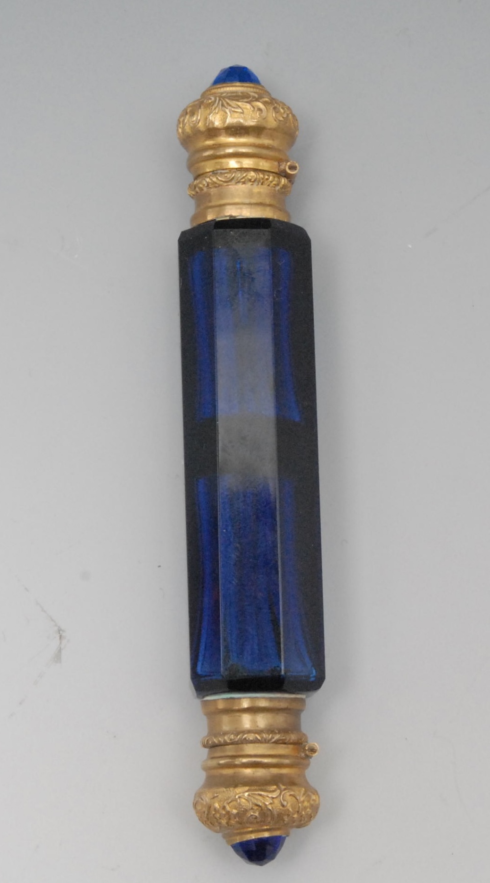 A 19th century gilt metal mounted blue glass double ended scent bottle, hinged covers cabachon set