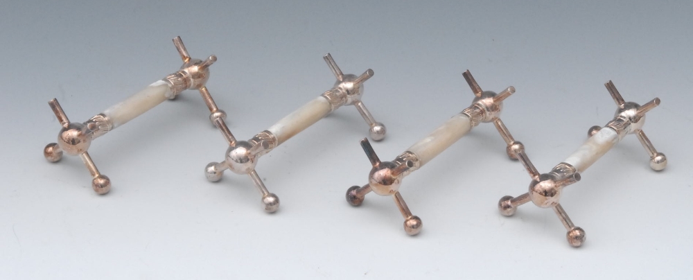 A set of four Victorian E.P.N.S and mother of pearl knife rests, X-shaped end supports, ball feet,