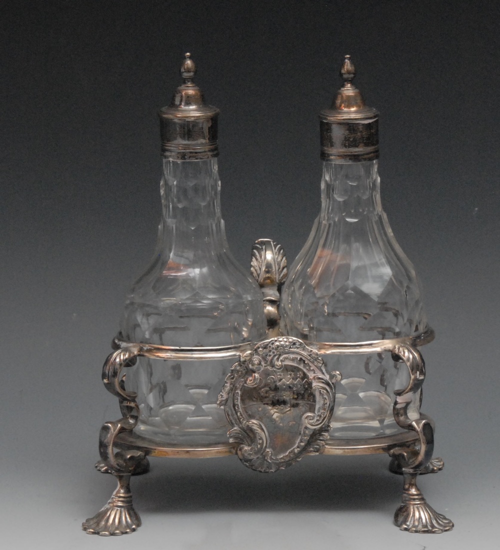 A George II two-bottle condiment stand, facetted glass bottles and covers, stand with engraved