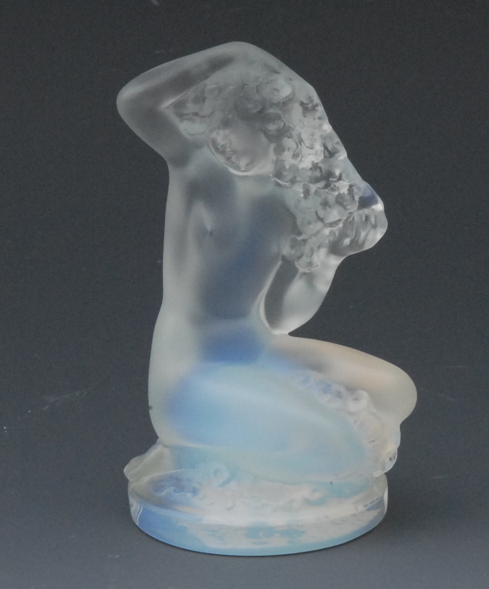 A Lalique frosted and opalescent glass figure, of a kneeling naked lady, holding a garland of