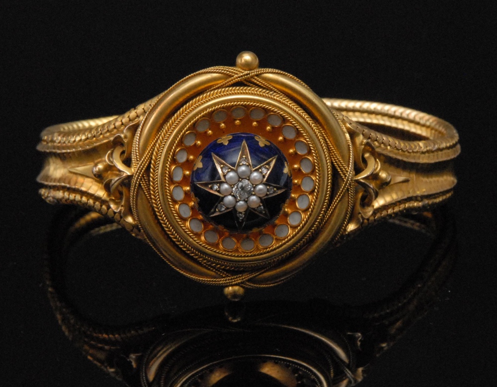 A mid 19th century gold bracelet, circular form with raised ball to centre set diamond and split