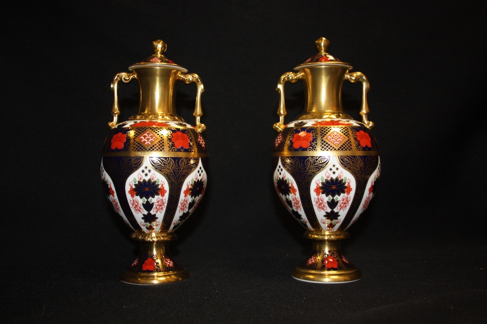 A pair of Royal Crown Derby 1128 pattern two handled Sudbury vases and covers