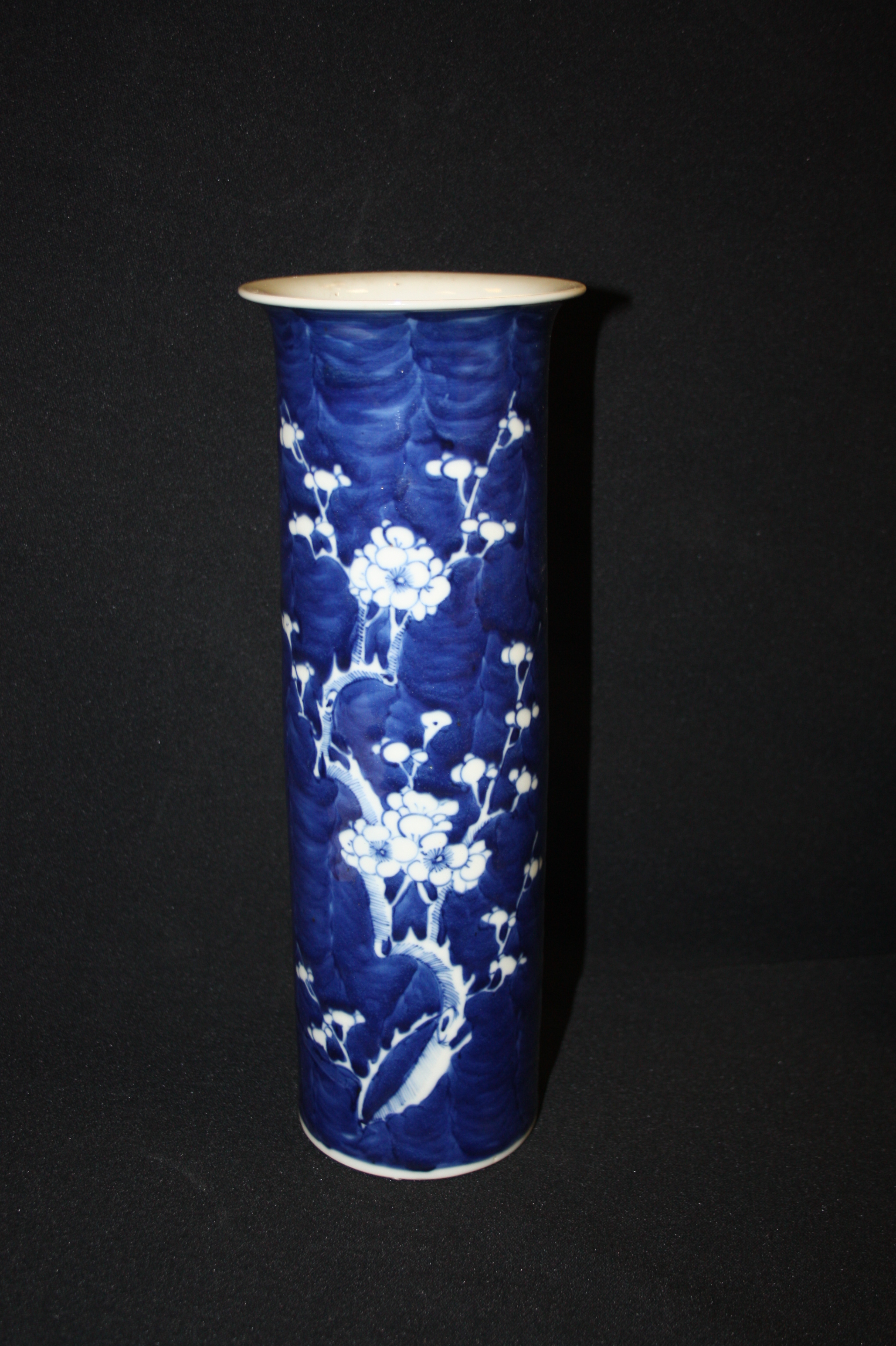 A Chinese blue and white porcelain cylindrical vase, painted with blossoming prunus, double ring