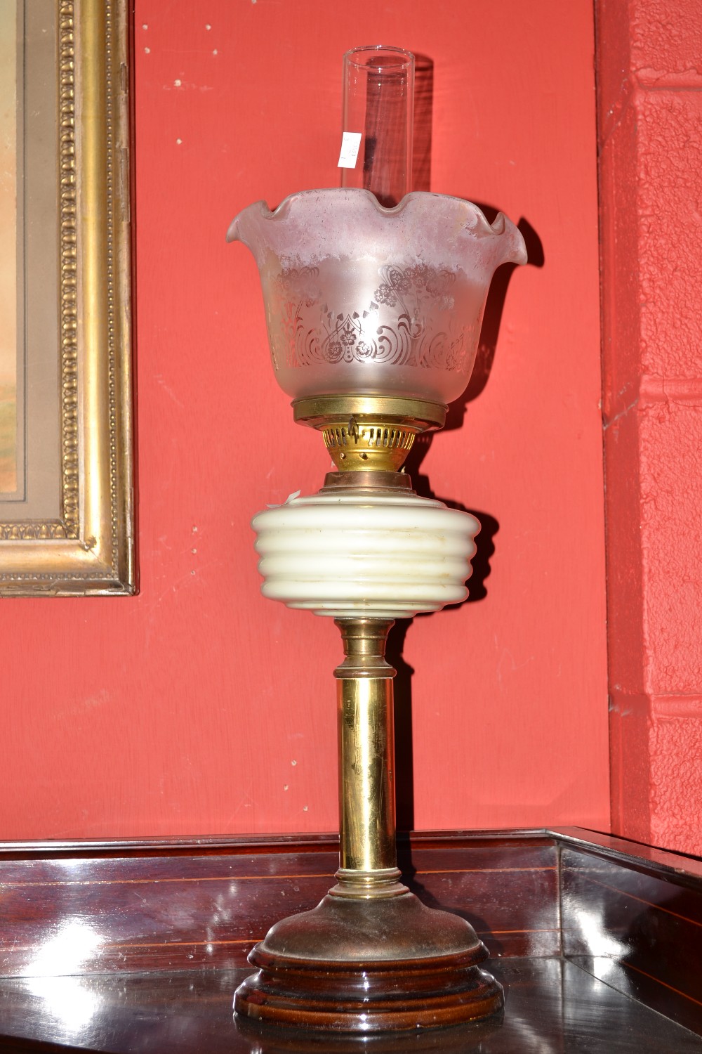 A late Victorian oil lamp brass column, frosted glass shade, milk glass reservoir.