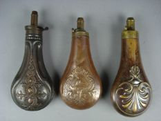 A copper and brass powder flask by G & J W Hawksley and two other copper and brass powder flasks. (