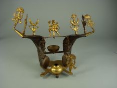 An Indian brass and horn pen stand, decorated with Hindu figures on a heart shaped stand.