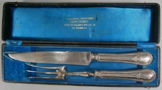 A French two-piece silver handled carving set with fox mask decoration, cased.