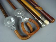 An ivory and white metal mounted walking cane, two other walking canes and two shooting sticks.