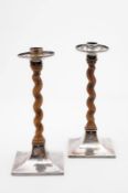 A pair of George V silver mounted candlesticks, in the Arts & Crafts style, maker Alfred Ernest
