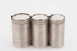 Fabergé, a silver three section graduated coin holder, of cylindrical ribbed form with Greek key
