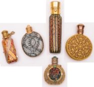 A collection of five early 20th century glass and gilt metal mounted scent bottles, of varying