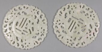 A pair of Chinese Jade medallions of circular form with pierced decoration of dragons and