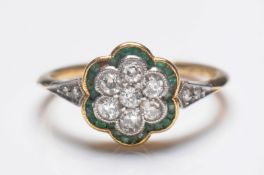An early 20th Century gold, diamond and emerald circular cluster ring, with central floral cluster