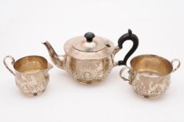 A George V silver three piece tea set, maker Charles Edwards, London 1919, having overall hammered