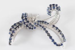 A sapphire and diamond mounted ribbon spray brooch with circular sapphires, brilliant and navette-