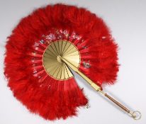 An early 20th century red Ostrich herl cockade fan with patent clasp and folding handle 37cm.
