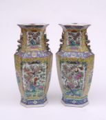 A pair of Canton famille rose vases of hexagonal section with buddhistic lion and puppy handles,