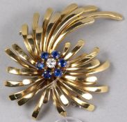 A sapphire and diamond mounted floral spray brooch stamped ‘18K’.