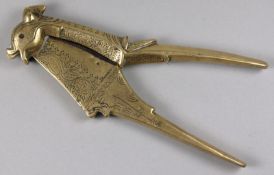 An 18th Century oriental brass cutter, the 4cm. steel blade enclosed in a brass scissor action