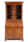 An 18th Century and later walnut bureau bookcase, the upper part with a moulded cornice, fitted with