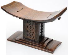 An African Ashanti tribe stool, of typical form, the rectangular curved top carved with a single