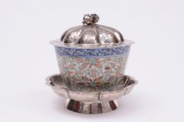 A Chinese porcelain ‘rice ware’ tea bowl or wine cup the exterior enamelled with stylised blooms and