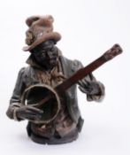 An Austrian cold painted terracotta figure of a negro banjo player modelled waist up wearing coat,