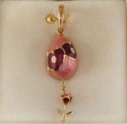 Fabergé. A modern diamond and enamel egg locket pendant accented with pink and dark red enamel and