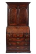 An early 18th Century oak bureau cabinet, the moulded cornice above two doors with ogee arched