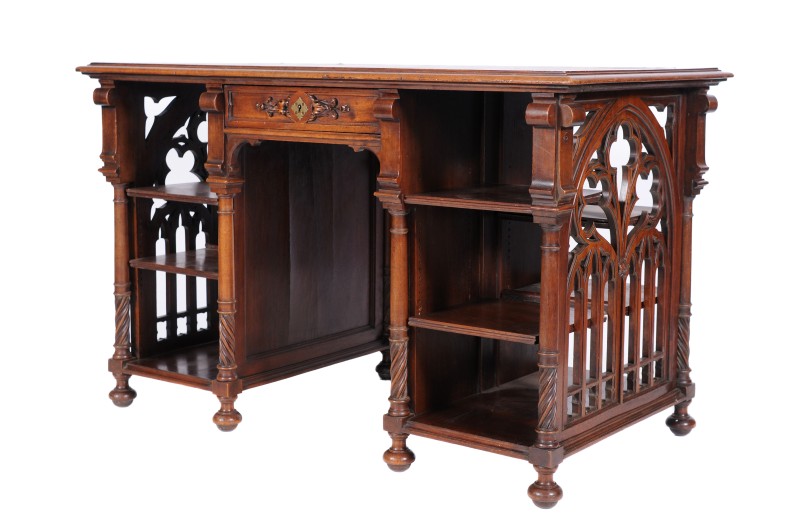 An unusual Victorian carved walnut kneehole library desk, the rectangular moulded top inset with a