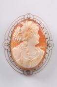 An oval shell cameo portrait brooch, the shell carved depicting a young woman, her hair adorned with