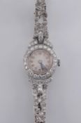 A lady’s platinum and diamond mounted cocktail wristwatch, the circular dial with Arabic numerals,