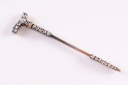 A late 19th century gold and diamond mounted riding crop jabot pin.