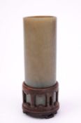 A Chinese jade small cylindrical brushpot the stone of dark celadon and russet colour, 10.5cm high