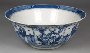 A Chinese porcelain bowl of circular form, the exterior painted in blue with panels of a figure in a