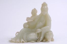 A fine Chinese carved celadon jade figure of Guanyin the seated goddess with her left arm resting on