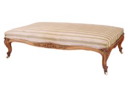A Victorian walnut framed boudoir stool, with upholstered rectangular top, foliate carved serpentine