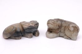 Two Chinese jade carvings of recumbant mythical beasts, the stone of mottled grey and celadon